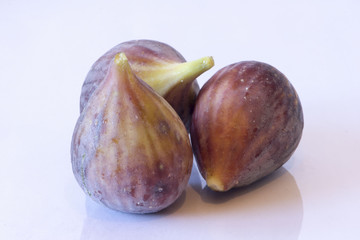 Three ripe figs on a white background