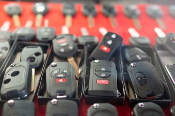 Locksmith stand with variety of car and van keys remote on red background