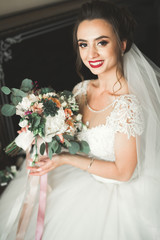 Naklejka premium Luxury bride in white dress posing while preparing for the wedding ceremony