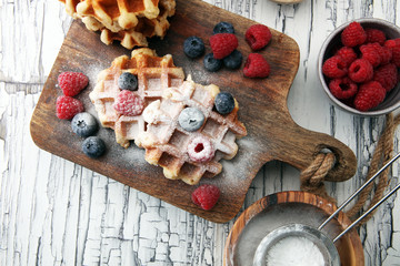 Traditional belgian waffles with fresh blueberries, sugar and raspberries.