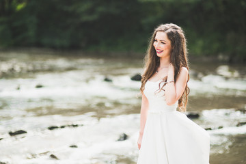 Fototapeta na wymiar Beautiful happy bride outdoors in a forest with rocks. Wedding perfect day