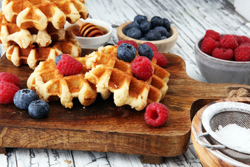 Traditional belgian waffles with fresh blueberries, sugar and raspberries.