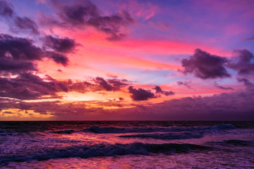 colorful sky as the sun rises and reflects on the wavey ocean