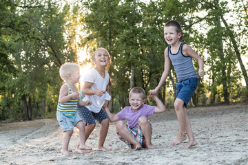 Young friends joined hands and jump on the beach resort town. Seashore and romantic sunset.