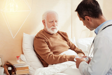 Fototapeta premium Sad grey-haired male person listening to his doc
