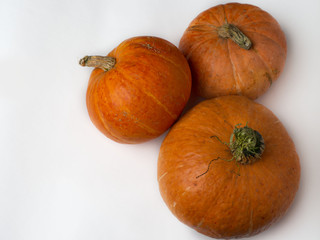Three pumpkins from the harvest. Different size and different taste. White background