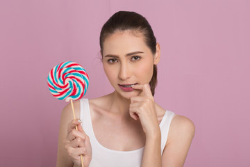 Portrait of happyBeautiful Woman holding lollypop with smiling. isolated on pink background