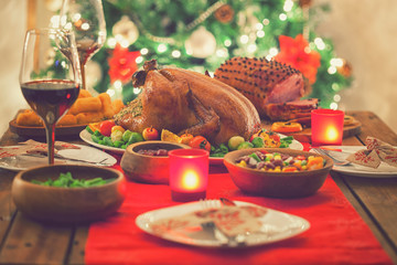 Stuffed Christmas turkey dinner served in front of a Christmas tree 