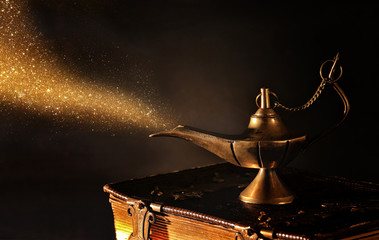 Image of magical aladdin lamp with gold glitter smoke. Lamp of wishes