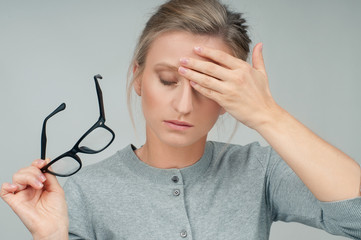 Tired woman with eyeglasses has headache