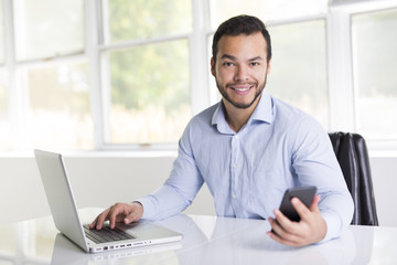 Fototapeta premium mexican attractive businessman on his 30s working at modern home office with computer laptop