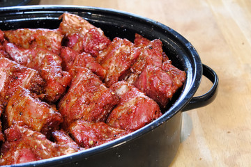 Ribs piled into a black roaster for slow cooking