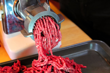 Closeup of meat coming out of a meat grinder