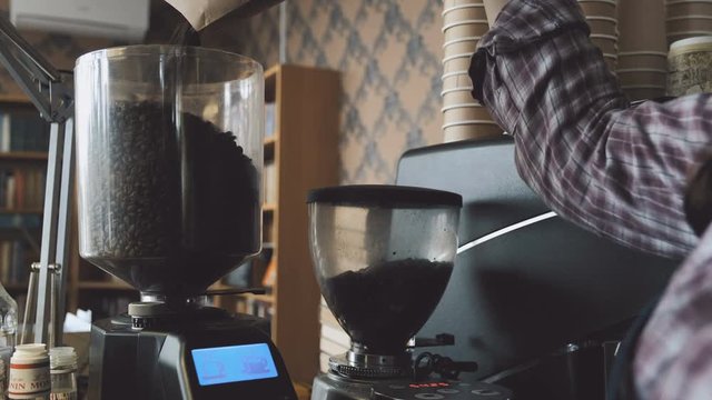 Barista refilling coffee beans in hopper