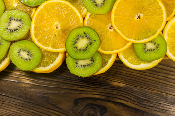 Naklejka na ściany i meble Sliced kiwi fruits and oranges on wooden table