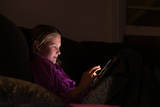 girl with ipad in a dark room
