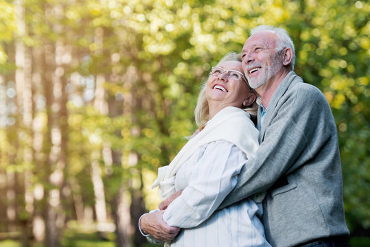 Happy elderly couple smiling outdoors in nature 
