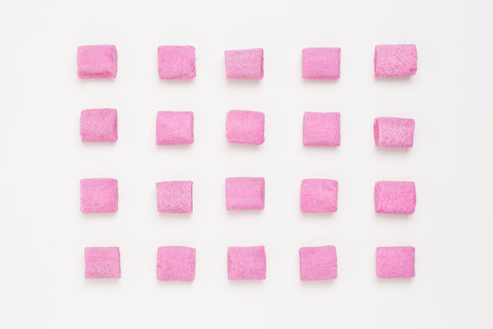 Rows of pink bubble gum on white background