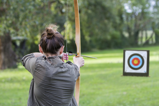 Woman archer to use a bow and arrow and shoot at a target