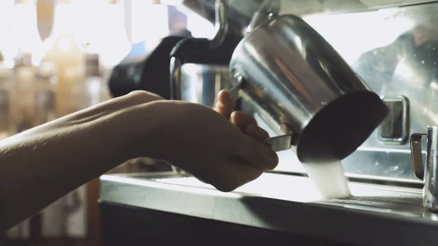 Barista cleaning coffee machine with steam 