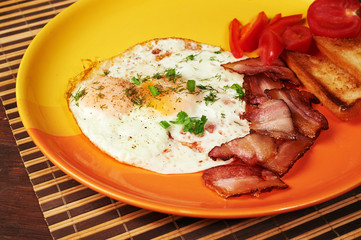 Breakfast - fried egg, tomatoes and bacon.