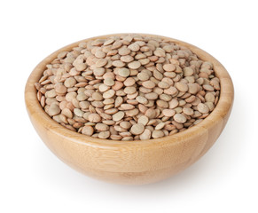 Uncooked lentils in wooden bowl isolated on white background with clipping path