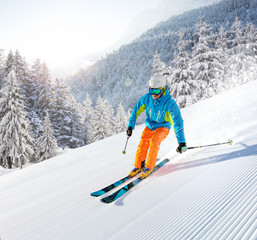 Skier skiing downhill in high mountains