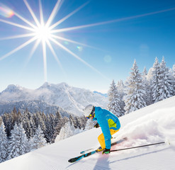 Skier skiing downhill in high mountains
