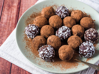 Homemade chocolate truffles with cocoa and coconut on the plate