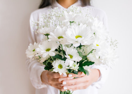Young woman holding beautiful white flower bouquet