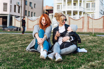 Mom and aunt play with a boy in the Park