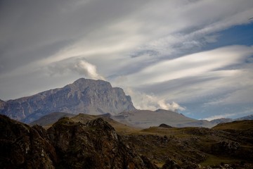 Горный пейзаж. Красивый вид на живописное ущелье, белые облака над высокими горами. Дикая природа Северного Кавказа