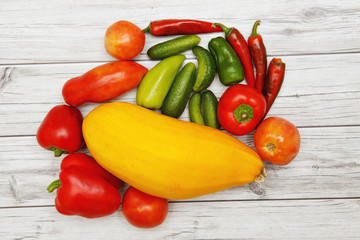 Vegetables and autumn leaves on bright wooden table.