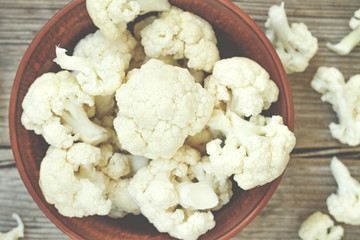 rustic style, Cauliflower in a clay bowl on a wooden table, top view,