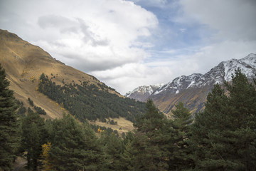 Горный пейзаж. Красивый вид на живописное ущелье, белые облака над высокими горами. Дикая природа Северного Кавказа