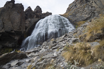 Fototapeta na wymiar Красивый водопад в горном ущелье, живописная панорама, дикая природа Северного Кавказа
