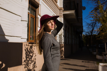 Fashion portrait of glamor model wearing trendy grey fall dress and red hat