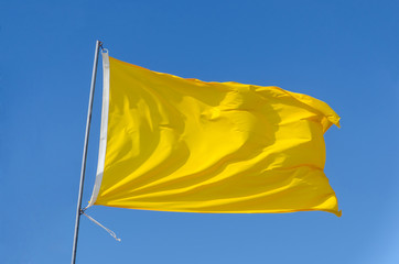 Big yellow flag waving on the sky