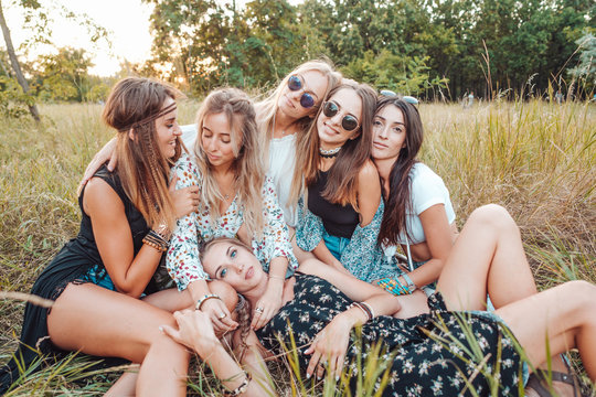 Six girls in nature are sitting on the grass.