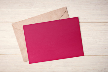 Blank red card and envelope on wooden table