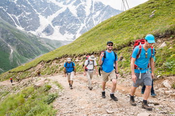 Portrait of a group of tourists with backpacks climbing a mountain
