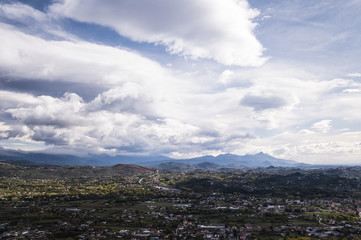 Aerial view of an Italian countryside with a dramatic and cloudy sky.