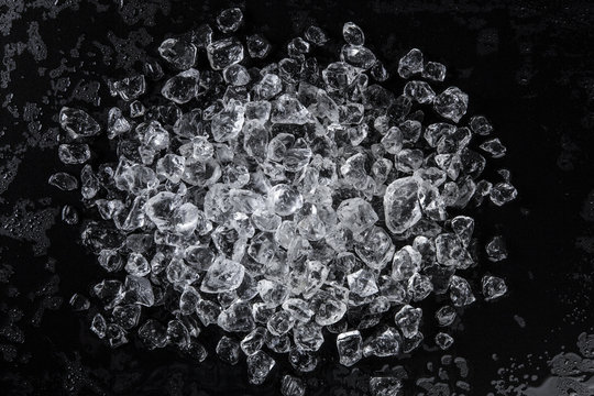 Pile of crushed ice on a black table. Top view