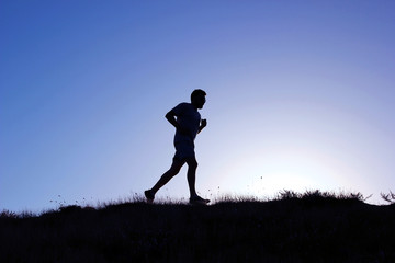 Running man silhouette at sunset