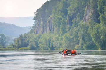 Team of athletes on an inflatable catamaran rafting on river,