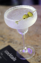 Margarita cocktail garnished with fresh olive