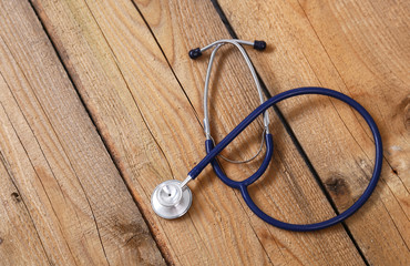 Closeup of a medical stethoscope, isolated on wooden background
