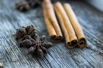 Cinnamon sticks and anise fruit on a wood background, christmas background