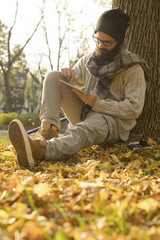 Man with beard using tablet outdoor