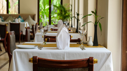 white cover sheet table and wooden chair in restaurant ready for the meal